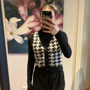 Stickad väst - En svart/vit mönstrad, stickad väst från H&M i strl M. Köpt för en halloween kostym så endast använd någon enstaka gång. 
