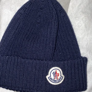 Moncler mössa Marinblå - Säljer nu min Moncler mössa då den ej kommer till användning (använd 2-3 gånger) Kvitto och tags finns!
