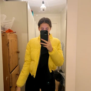 Jacka - Kort, gul pufferjacka från H&M. Snörning kan justera storleken på jackans nedersta del.  Storlek XS. Nyskick. 