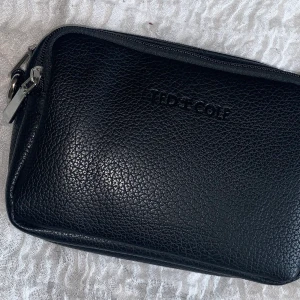 Svart väsk  - Såljer denna svarta väska aldrig använd kan bpda användas som axelrems väska och magväska mycket praktisk 