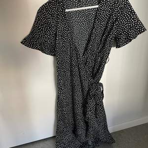 En svart och vit prickig omlottklänning från Veromoda, använd 1 gång.   Priset är inkl frakt 