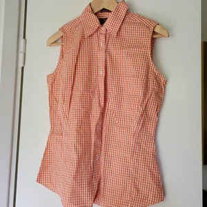 Blus stl 38 - Somrigg snygg Rutig ärmlös blus i bomull. Feminin, insväng modell Orange/vit. Stl 38 Logg H&M. Använd, välvårdad.