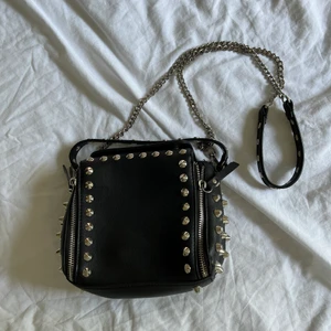 Liten väska med detaljer  - Liten väska med en längre band och två fickor  God skick 