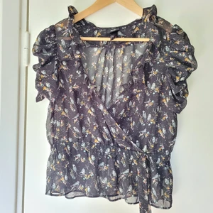 Blus topp sl40 - Superfin tunn svart topp m mönster. Volangkant. Fast omlott v-ringning. Polyester. Obetydligt använd -som ny!