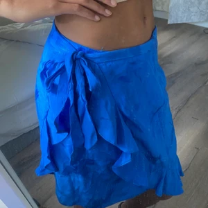 Blå kjol - Blå omlottkjol från River Island i strl 12 (M).