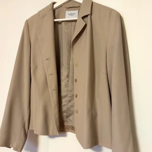 Beige kavaj med knappar - Snygg beige kavaj med klassisk design och knappar framtill. Storlek 44, men passar utmärkt på mig som är 36. Blir mer oversized och bred istället!🤍