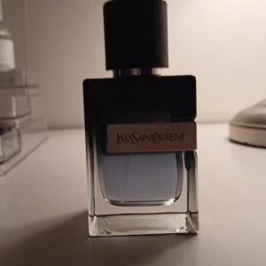 Yves Saint Laurent Eau de Parfum, byten funkar bra! - Elegant parfym från Yves Saint Laurent i en stilren flaska med mörk överdel och transparent botten. Doften är intensiv och sofistikerad, perfekt för den som vill ha något extra. Flaskan rymmer 60 ml och har en modern design som passar in i alla miljöer.