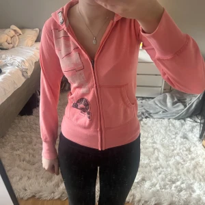 Rosa y2k zip up  - Säljer en snygg rosa hoodie med dragkedja och coolt tryck på bröstet. Sitter som en fitted XS men är barnstorlek. 