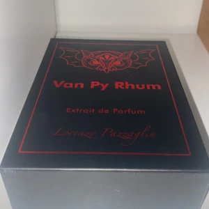 Van Py Rhum Extrait de Parfum - Andvändt 5 ml max. Upptäck Van Py Rhum, en exklusiv Extrait de Parfum från Lorenzo Pazzaglia. Flaskan är elegant svart med en dekorativ logotyp på korken och en stilren etikett med fladdermusdesign. Perfekt för den som söker en unik och djärv doftupplevelse.