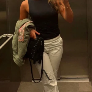 Svart axelväska med fransar från Maje - Studded suede bag M från Maje tillsammans med axelremmen som tillhör. Väskan är inköpt i butiken på Biblioteksgatan i Stockholm 2021 för 2749kr och finns inte längre kvar att köpa.