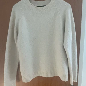 Beige stickad tröja från Vero Moda - Säljer en mysig beige stickad tröja från Vero Moda. Tröjan har en rund halsringning och långa ärmar, perfekt för kyligare dagar eller en sommarkväll. Den är enkel och stilren, vilket gör den lätt att matcha med olika outfits. Den har ett lagat hål som ni ser på bild 3 men det är inget man ser/tänker på. Bild 5 är insidan av det lagade hålet men det känns inte eller något sånt! Jag säljer denna då jag har köpt en ny vi stickad tröja o denna inte kommer till användning.