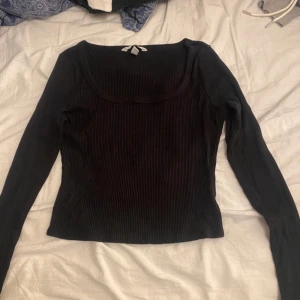 Svart ribbad tröja från H&M - Säljer en stilren svart ribbad tröja från H&M. Tröjan har en rund halsringning och långa ärmar, perfekt för en enkel och snygg look. Passar bra till både jeans och kjol. 🖤