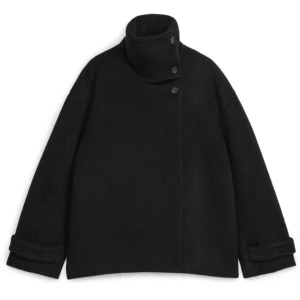 Svart kappa med knappar - det ser ut som smuts på andra bilden men de är bara ljuset !!snyggaste svarta kappan från arket😍. nypris typ 2300 men säljer billigare pga ett hål i fickan som inte syns när man har på sig den (bild 4). 