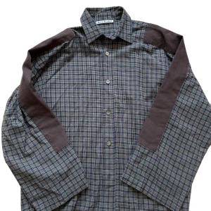 Acne Studios skjorta - Snygg rutig skjorta från Acne Studios i blå och brun färg. Skjortan har långa ärmar och knappar framtill.
