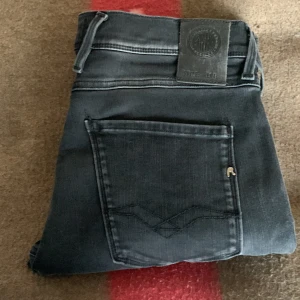 Svarta replay jeans  - Säljer ett par svarta Replay jeans i storlek 33 (midja) och 34 (längd). Jeansen är i gott skick och har en modern passform med en stilren svart färg. Perfekta för både vardagsbruk och lite finare tillfällen. Bekväma och slitstarka – ett måste i garde