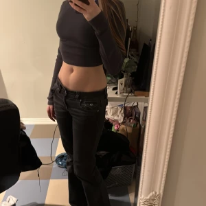 Grå croppad topp från H&M Divided - Säljer en stilren grå croppad topp från H&M Divided. Toppen har långa ärmar och är perfekt för en trendig look. Passar bra till både jeans och kjol.