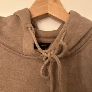 Beige hoodie från New Look - Säljer en beige hoodie från New Look. Ficka fram. Väldigt skön och fin men lite använd! Två små fläckar fram och normalt nopprig en hoodie blir efter ett tag, se sista bilden.