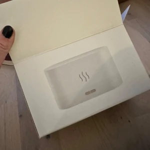 Vit aromadiffusor multifunktionell luftfuktare  - Säljer en vit aromadiffusor med en stilren design. Perfekt för att sprida en behaglig doft i hemmet. Kompakt storlek som passar i alla rum. Enkel att använda med en knapptryckning. Dessutom är enheten utrustad med en inbyggd RGB LED-lampa som skapar en eldeffekt samt möjlighet för aromaterapi.                                                                  - Tyst Drift: Njut av ångans lugnande effekt utan störande ljud, idealisk för lättsovande barn och ostört arbete. - Låg Energikonsumtion 