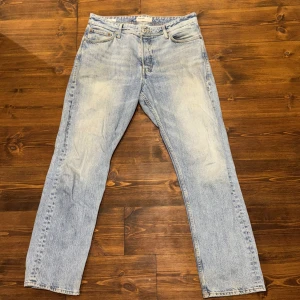 Ljusblå jeans - Säljer ett par ljusblå jeansbyxor med en loose fit. De har en klassisk femficksdesign och är perfekta för en avslappnad stil. Midjan är w32 och längden är 34. Passar bra för en casual look. Mycket gott skick förutom smuts som säkert går att få bort.