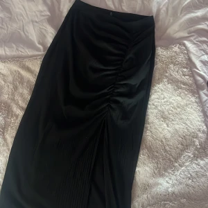 Lång svart kjol med slits  - En lång svart kjol med slits från ONLY i storlek M. 