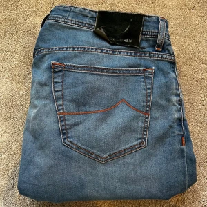 Blå jeans från Jacob Cohën - Skick: 9/10, lappen där bak har lossnat lite - Storlek: 36 - Längd:107cm Midja:46cm ben:18cm - Nypris: 5000 kr+