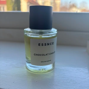 Chocolat Chaud Eau de Parfum från Essnce - Upptäck en förförisk doft med Chocolat Chaud Eau de Parfum från Essnce. Denna parfym kommer i en stilren glasflaska med svart lock och en etikett som ger en elegant touch. Perfekt för dig som älskar varma och söta dofter.