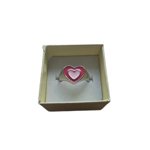 Ring med hjärta i rosa och vitt - Charmig ring med ett hjärta i rosa och vitt. Perfekt för att lägga till en söt detalj till din outfit. Okänt Material, US 6.5 eller 16.9 mm