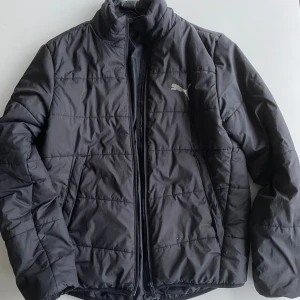 Svart pufferjacka JUNIOR från Puma - Ett hål i höger arm, annars i fint skick.