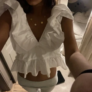 Vit blus med volanger - Säljer en söt vit blus med volanger och v-ringning. Man kan matcha me vad som, jeans, kjol, shorts💕