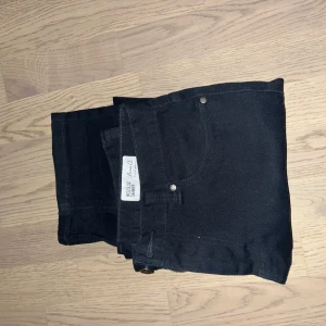 Svarta jeansbyxor från Levis - Snygga svarta jeansbyxor från Levis med en klassisk design. De har en dragkedja och knapp framtill samt fem fickor. Perfekta för en stilren look.