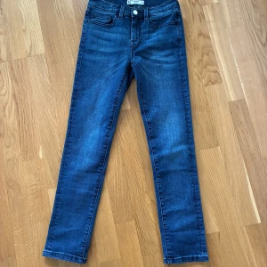 Blå jeansbyxor, 2 par - Snygga blå jeansbyxor med en klassisk design. De har en knapp och dragkedja framtill samt fem fickor. Perfekta för en avslappnad stil.1 par helt nya och andra paret bra skick. 