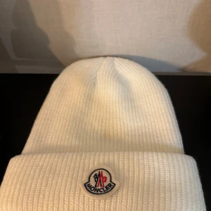 Vit stickad mössa -  - Snygg vit stickad mössa! ONE SIZE. Finns en liten smink fläck i mitten som försvinner vid ttt, knappt märkbar. Men viktig och veta. Endast prövad , ej använd. 