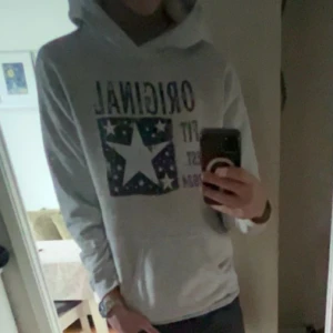 Grå hoddie från Scndi - Säljer en grå  hoodie med texten 'ORIGINAL' och ett stjärnmönster på framsidan. Perfekt för en avslappnad stil. Hör av dig vid intresse! 