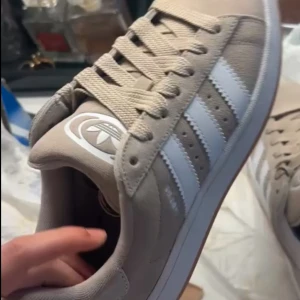 Beige adidas Campus sneakers mocka - Snygga beige adidas Campus sneakers i mocka. Använda 2-3 ggr. Kommer med beige och vita snören med. Kartong ingår också. Storlek 37 1/3.