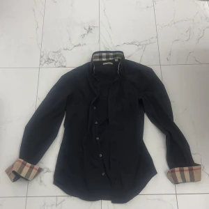 Svart Burberry skjorta XS - Svart Burberry skjorta använd 2-3 gånger, nypris runt 2500-3000kr, storlek xs passar lika gärna dig med storlek s  
