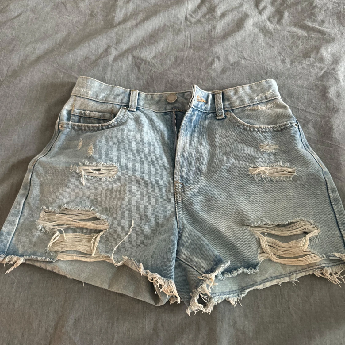 Ljusblå slitna jeansshorts