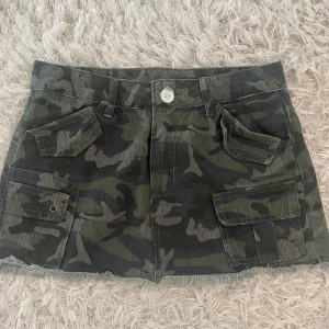 Militär kjol - Skitsnygg militärmönstrad jeanskjol! Älskar egentligen denna, men den har inte kommit till någon användning alls. Har aldrig hittat nåt tillfälle att ha på mig den. 