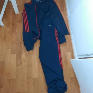 Adidas tracksuit - En adidas tracksuit som inte kommit till användning, är M i manstorlek men hade ingen mansmodell som kunde visa hur den sitter... skriv vid frågor och fler bilder!! Säljs tillsammans för 250 kr eller 150 var för sig. Nypris 500 kr