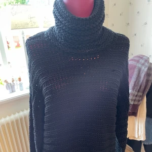 Svart stickad polotröja från Object - Svart grovstickad polotröja från Object med oversized krage och lång ärm. Tröjan har ett luftigt, öppet stickmönster och är perfekt för lager-på-lager. 