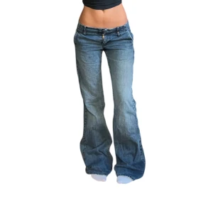 Blå bootcut jeans med låg midja - Snygga blå jeans med bootcut passform och låg midja. Klassisk femficksmodell med dragkedja och knapp framtill. Jeansen har en cool, lite sliten tvätt och är tillverkade i mjukt denimtyg som sitter skönt. Perfekta för dig som gillar retrovibbar och avslappnad stil.