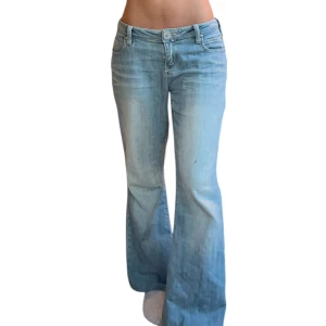 Bootcut ljusblå jeans lågmidjade - Snygga ljusblå bootcut jeans från Orsay med klassisk femficksdesign och låg midja. Jeansen har en lätt tvättad look och är tillverkade i mjukt denimtyg som sitter skönt. Perfekta för dig som gillar retrovibbar och vill ha en avslappnad stil.