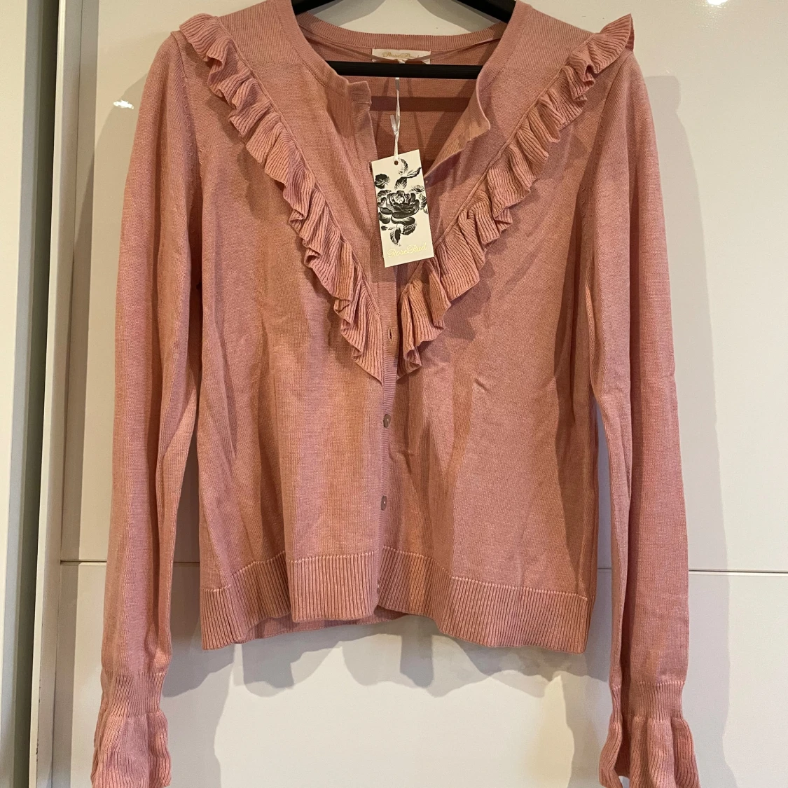 Rosa kofta med volang från RoseBud