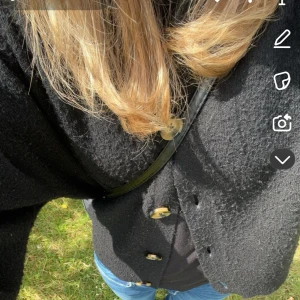 Svart stickad kofta med knappar - Mysig svart stickad kofta med stora, snygga knappar framtill. Koftan har en lite loose passform och är perfekt att slänga över en t-shirt eller topp. Passar grymt till jeans och funkar året runt när du vill ha något extra lager.