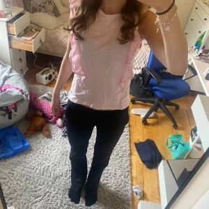 Ljusrosa volangtopp - Supersöt ljusrosa topp med volangdetaljer längs axlarna. 