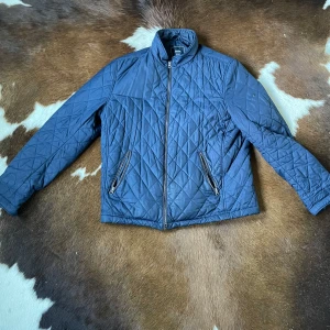  Boomerang jacka - Quiltad jacka från Boomerang i mörkblå färg med snyggt rutmönster. Jackan har två framfickor med dragkedja, ståkrage och hel dragkedja framtill. Storlek XL passar också L. Tveka inte på att göra av dig vid frågor!