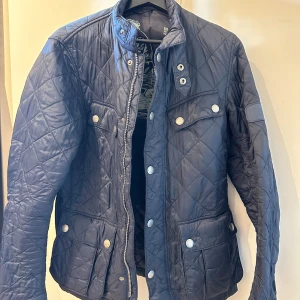 Mörkblå Barbour Jacka  - En väldigt snygg mörkblå Barbour jacka som är perfekt inför hösten! Jackan är i fint skick och nypris ligger på runt 3000 kr. Jackan är i storlek S och passar om man är runt 180 cm lång. Hör gärna av er vid funderingar!
