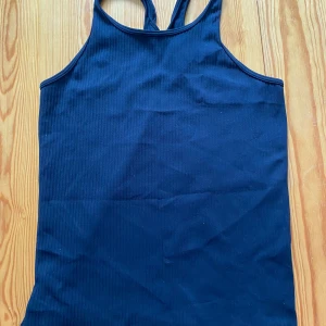 Svart linne - Säljer en svart ribbad linnetopp som passar bra både på gymmet och när man springer!