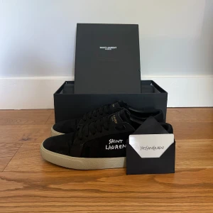Svarta Saint Laurent sneakers - Svarta Saint Laurent sl/06 sneakers. Skick 9,5/10, endast använda ett par gånger. Säljer vidare då de är för små. Slitningarna som syns på bild är del av design och inget att oroa sig för. Storlek 42, true to size. 