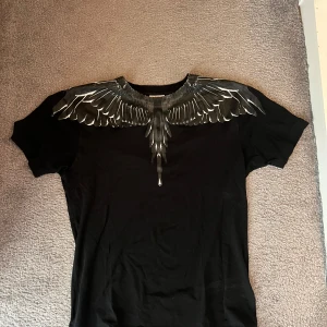 Marcelo burlon T-shirt - Hej jag säljer nu min svarta Marcelo Burlon T-shirt då den inte används längre, jag köpte den för 2,9 för cirka 2 år sedan på farfetch men hittar dock inte kvittot på mailen. Lite små slitningar på båda axlarna för den tvättats en del men inget man lägger märket till, priset kan diskuteras vid snabb affär