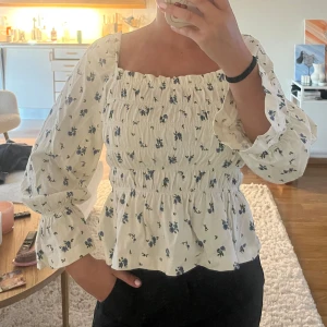 Blommig blus - Supersöt blommig blus i vit med små blå blommor.
